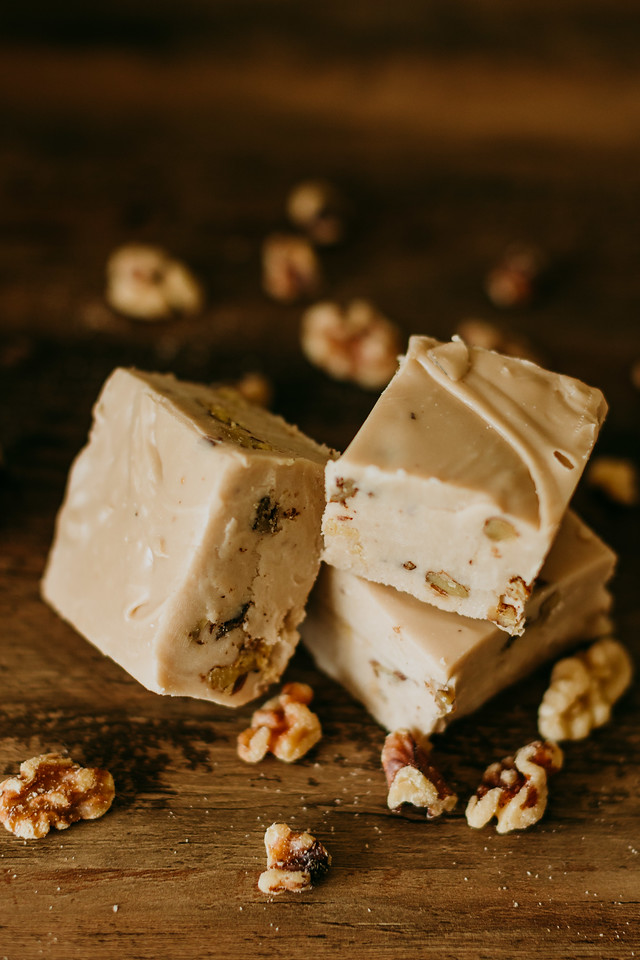 maple walnut fudge with maple soaked walnuts scattered around