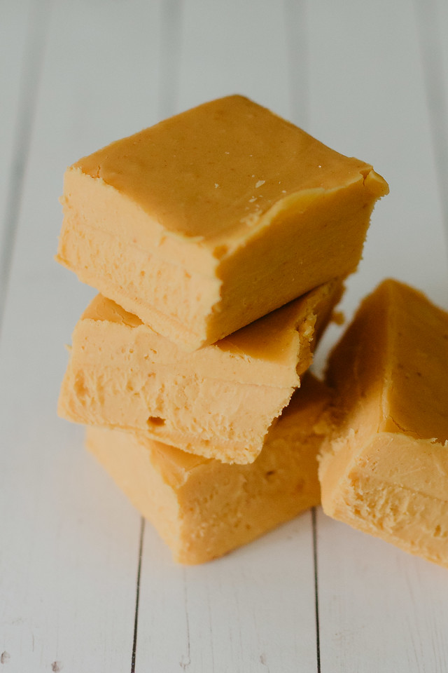 squares of pumpkin fudge stacked on a wood table