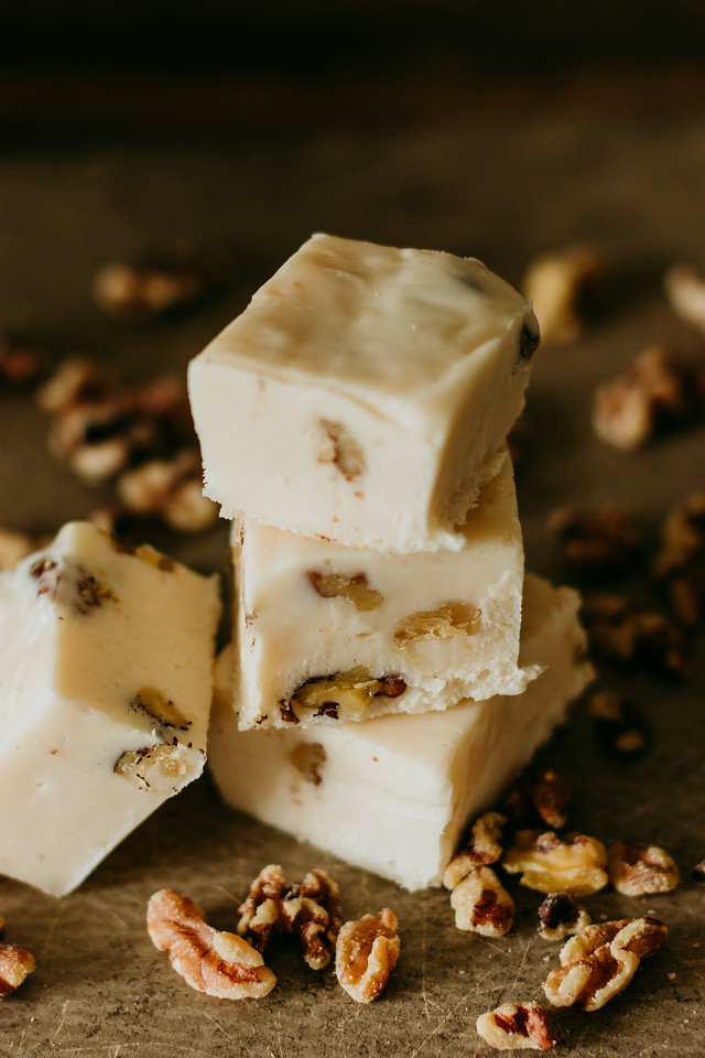 vanilla walnut fudge stacked up with walnuts surrounding it